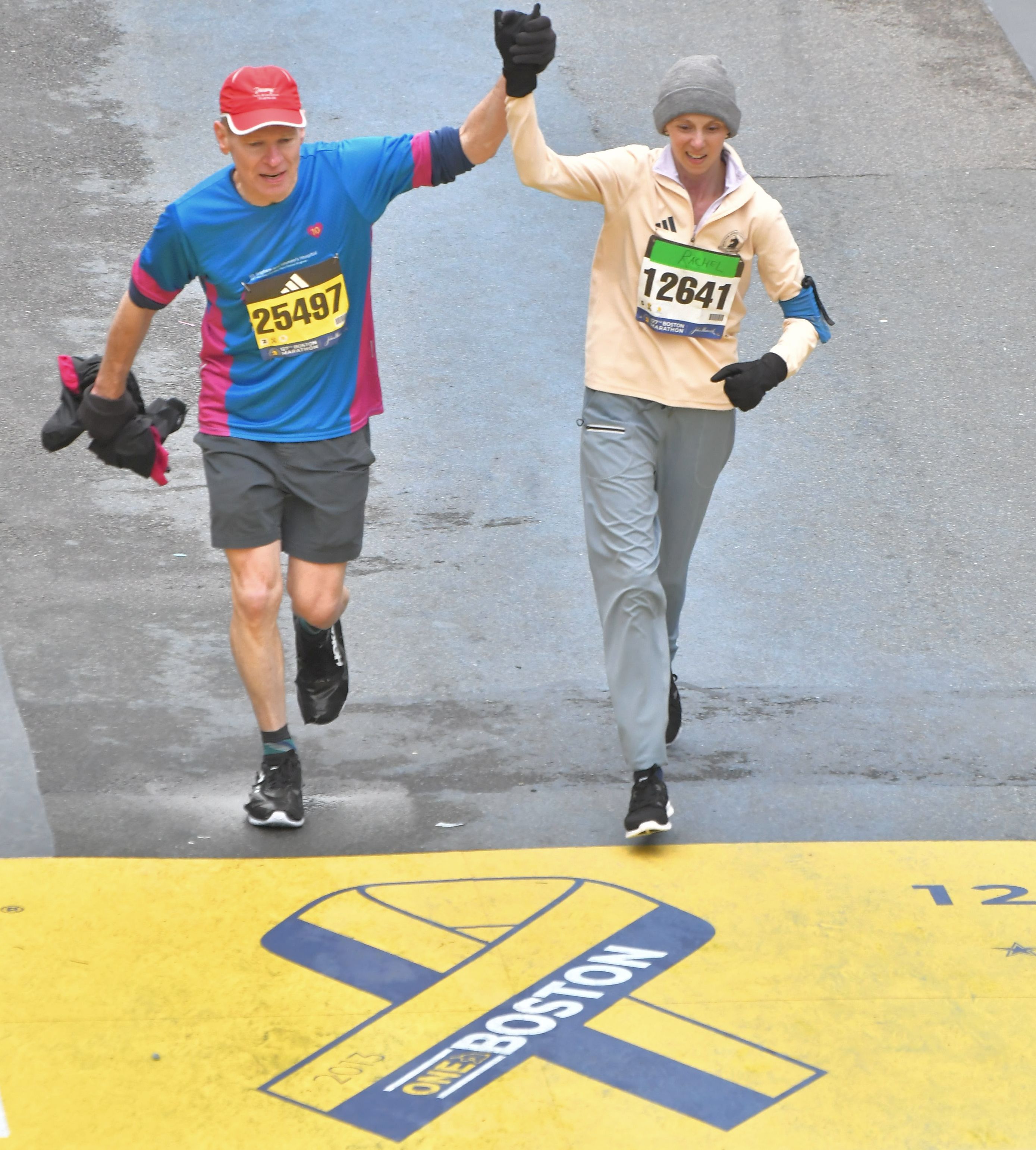 Rachel and Tim crossing the Boston Marathon finish line